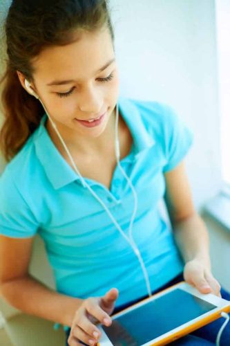 girl using tablet with earbuds