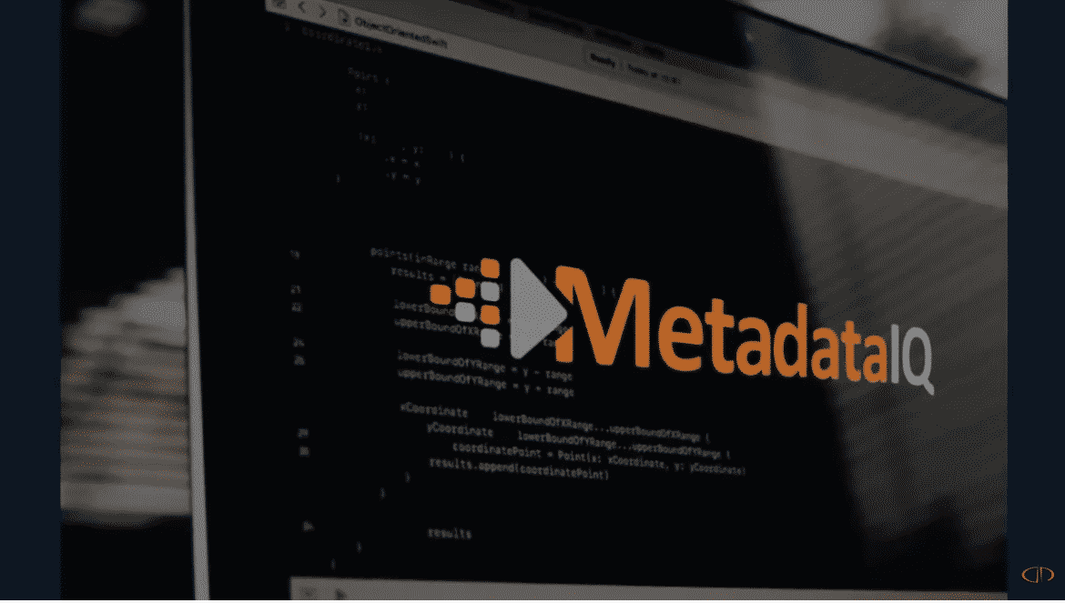 A computer screen displays code in the background with the MetadataIQ logo and a white play button overlayed in the center. The logo features orange and gray elements.