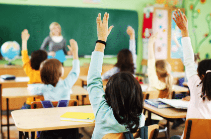 students in class raising hands