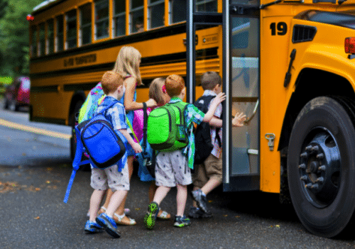 students getting on a school bus