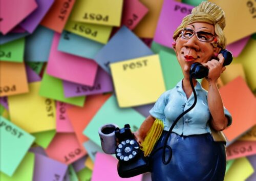 Bad teacher on the phone, too busy to help Post-it wall, arms loaded