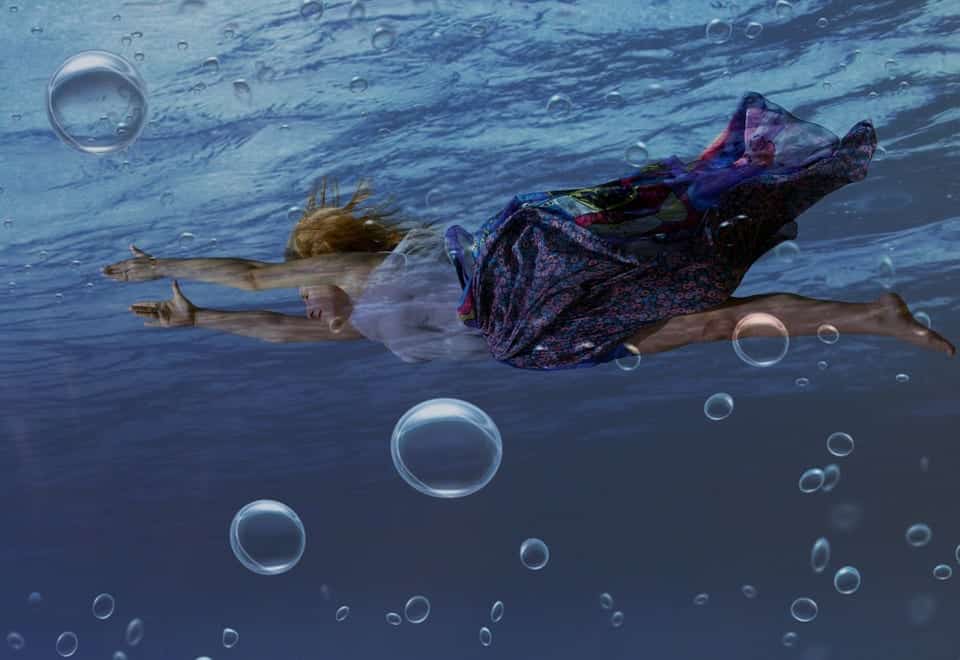 Fully clothed woman swimming with bubbles