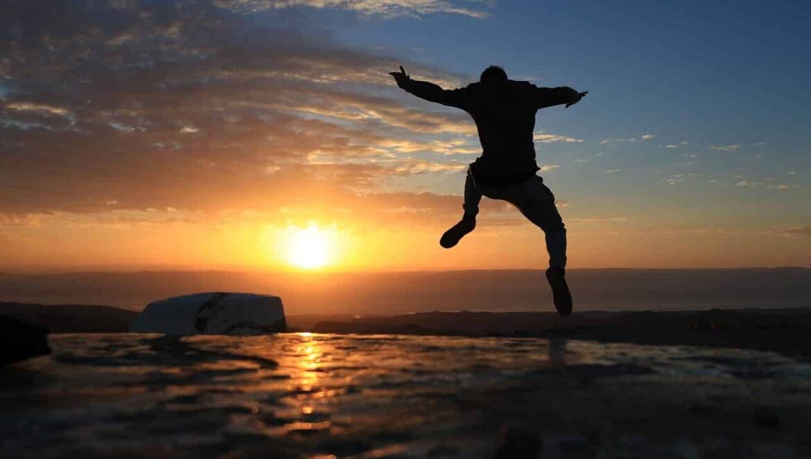 man happy leaping sunset