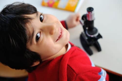 A young student with a microscope