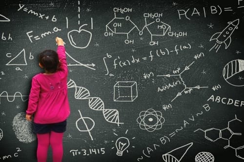 Little girl writing on blackboard - Learning and knowledge concept