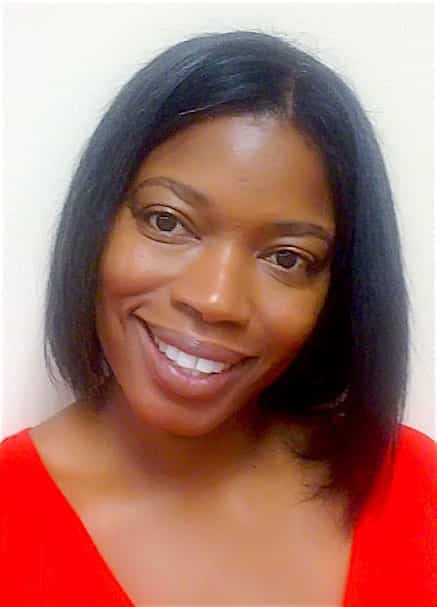 A woman with straight, shoulder-length black hair smiles at the camera. She is wearing a bright red top and is posed in front of a plain, light-colored background.