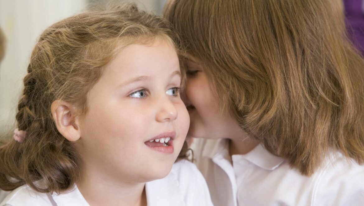 two schoolgirls sharing a secret