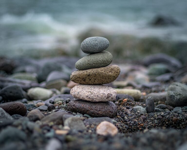 A serene stack of balanced stones with a sea backdrop, symbolizing harmony and b