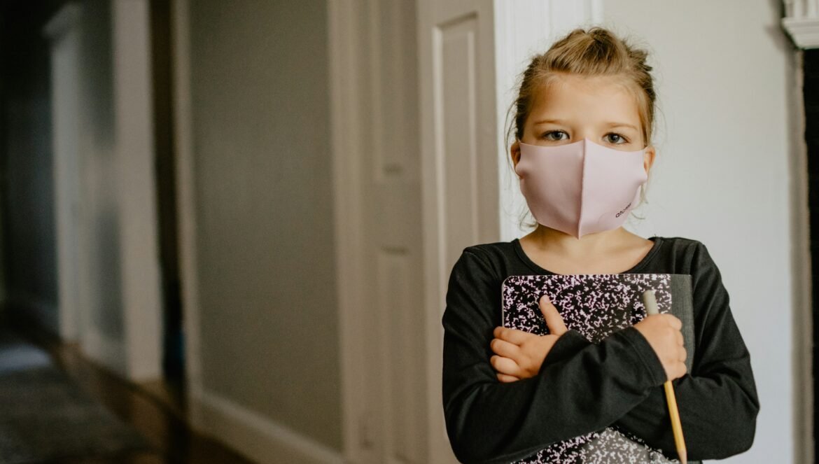 Woman in black cardigan wearing white mask | edCircuit Woman in black cardigan wearing white mask
