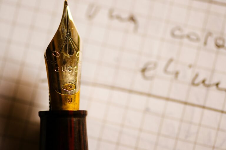A close-up of a golden fountain pen nib on paper