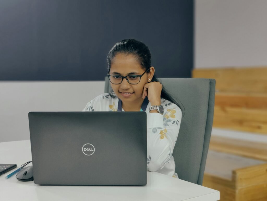 A woman sitting in front of a laptop computer | edCircuit A woman sitting in front of a laptop computer
