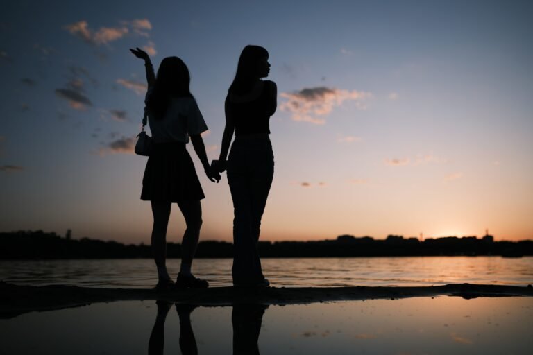 Romantic silhouette of a couple holding hands by the beach at a serene