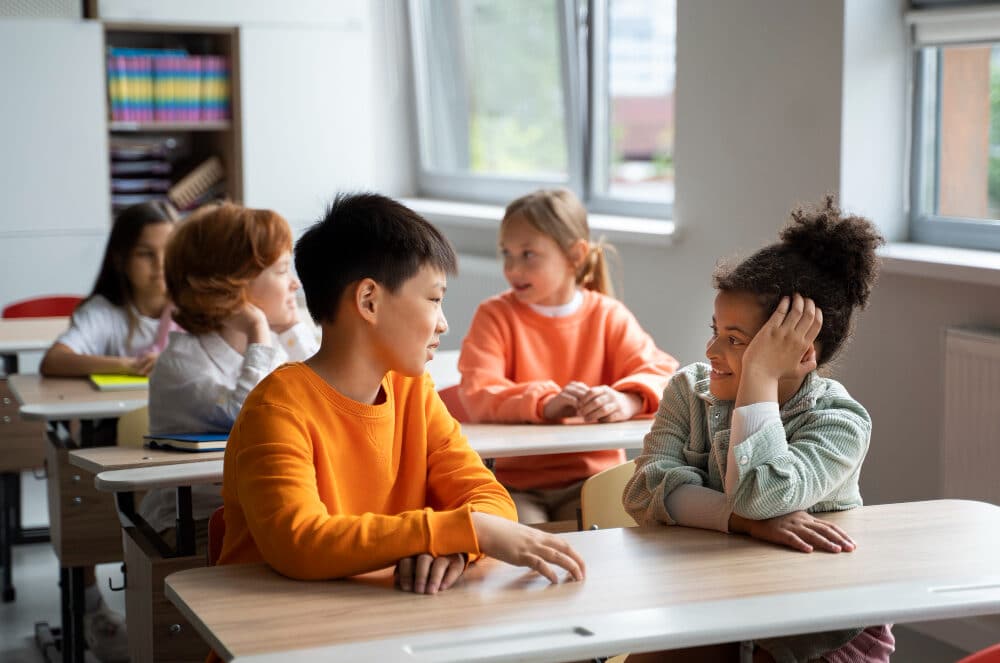 children talking with eacher in their classroom