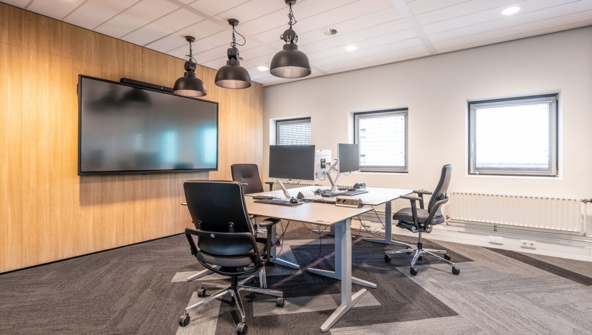 Spacious well lit office conference room featuring modern computers a