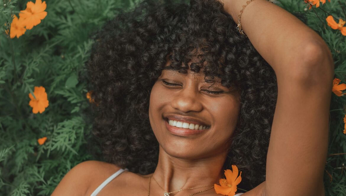 A woman smiling with flowers in the background