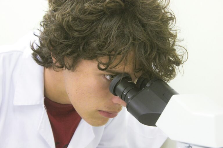A young scientist examines through a microscope
