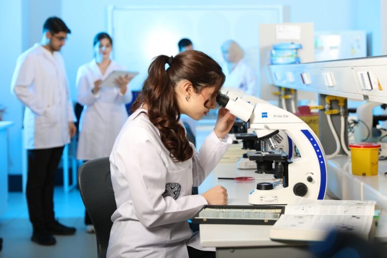 Young female scientist examining samples under a microscope in a moder