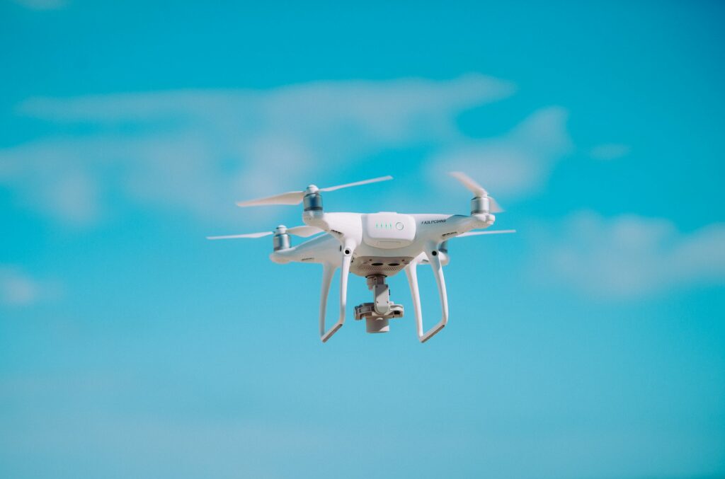 White quadcopter flying during daytime