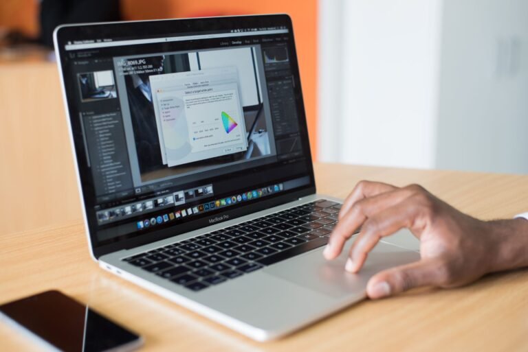 A person editing photos on a laptop in an office, showcasing technolog