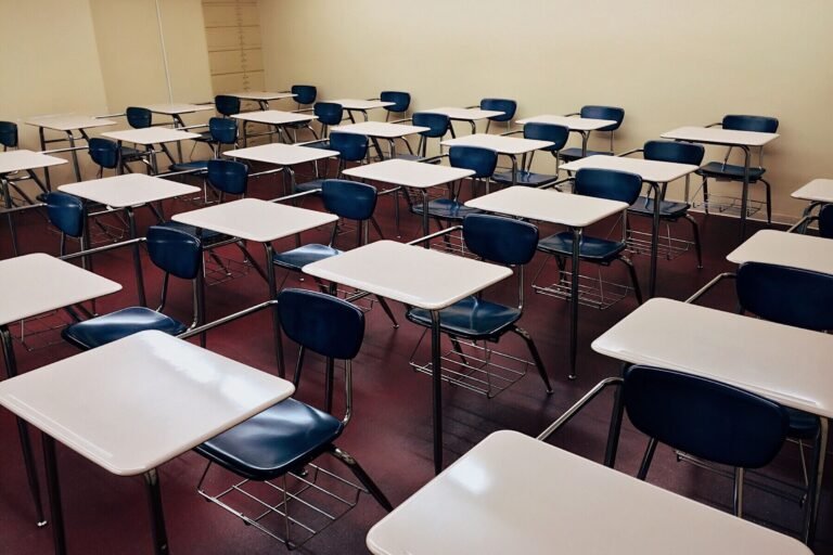 An indoor view of a modern, clean classroom with rows of empty desks a