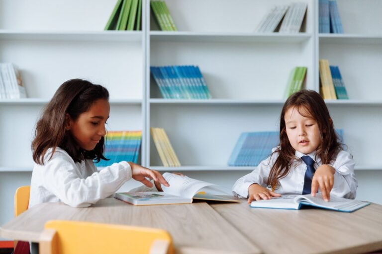 Two young girls enjoying books in a vibrant school library setting