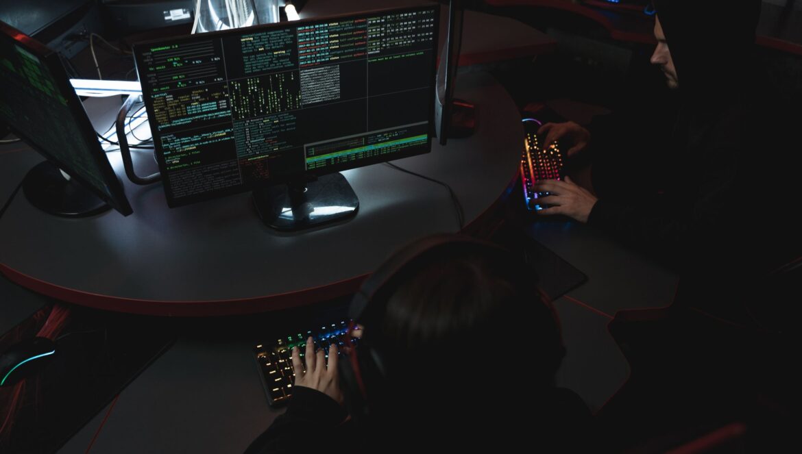 A group of people in a dark room working on computers related to cybe