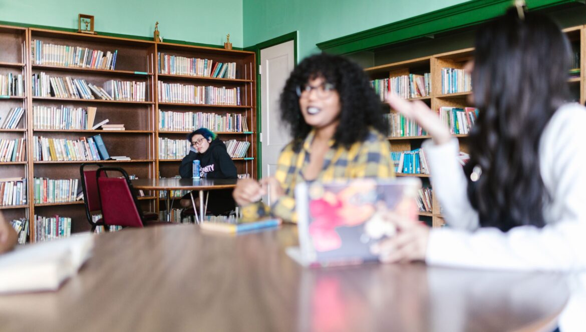 Group of students engaging in a lively discussion in a library setting