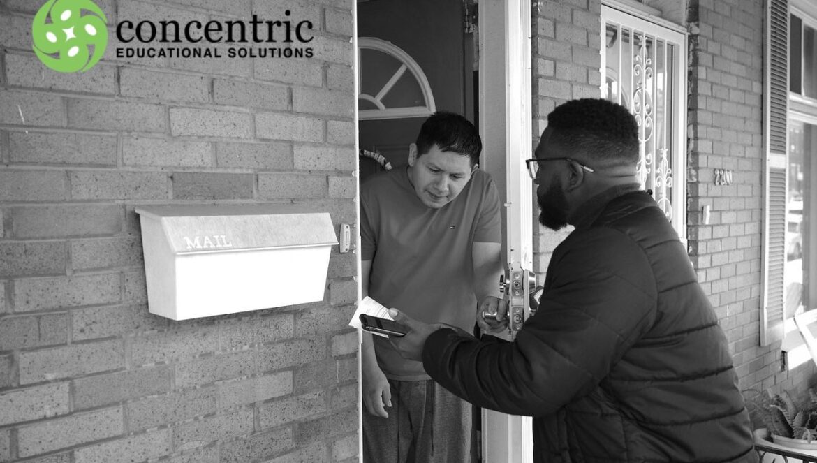 Two men at a brick doorstep exchange a small parcel one hands it to the other inside an open door with a concentric educational solutions logo in the corner