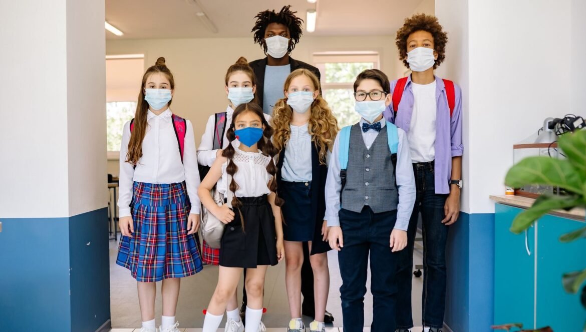 A diverse group of schoolchildren wearing masks in a classroom hallway | edCircuit A diverse group of schoolchildren wearing masks in a classroom hallway