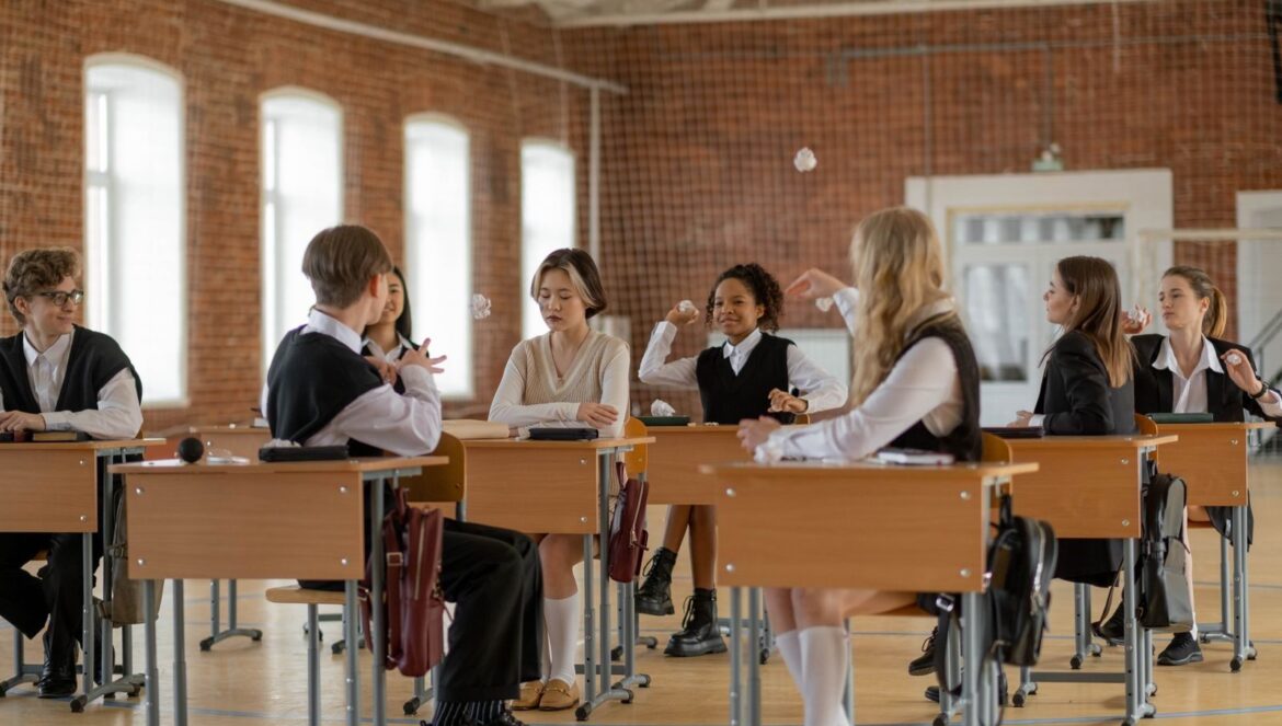 A diverse group of students wearing uniforms interacting in a classroom emphasizing school life and education