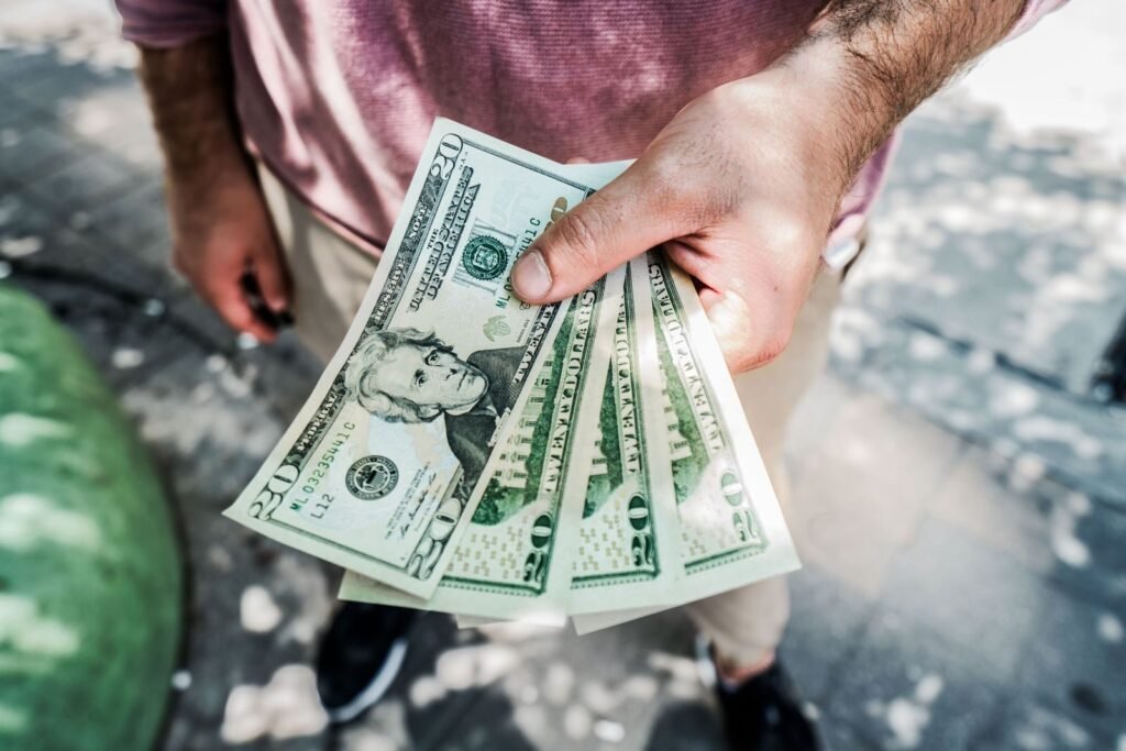 A person holding several twentydollar bills outdoors depicting payment or financial transaction | edCircuit A person holding several twenty dollar bills outdoors depicting payment or financial transaction