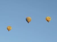 A serene image of three hot air balloons floating gracefully in a clea