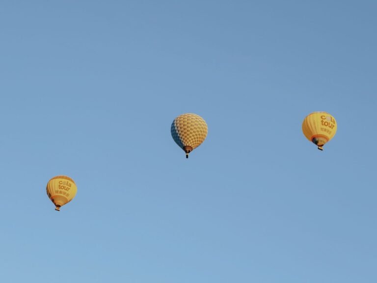 A serene image of three hot air balloons floating gracefully in a clea