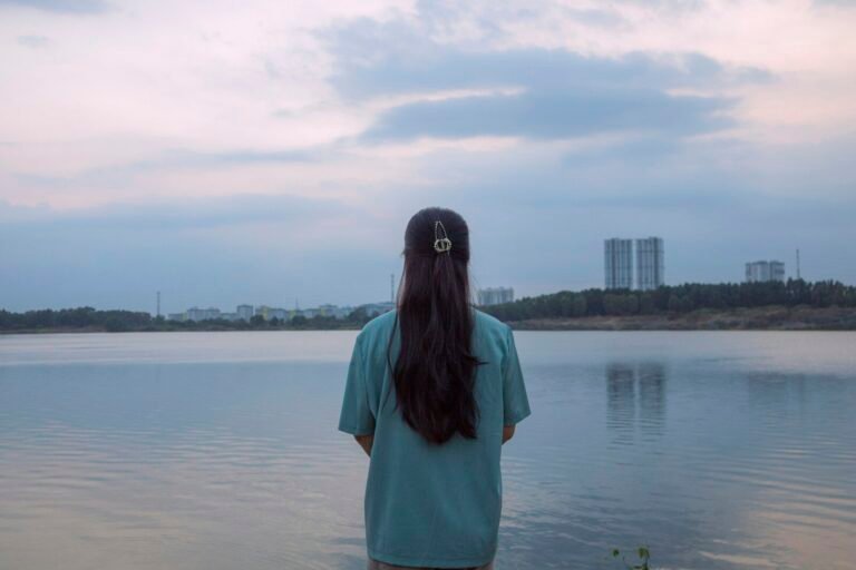 A woman standing in the water looking at the sky
