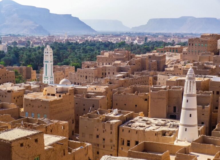Aerial view showcasing the traditional architecture of a historic town in Yemen with iconic towers and desert landscape