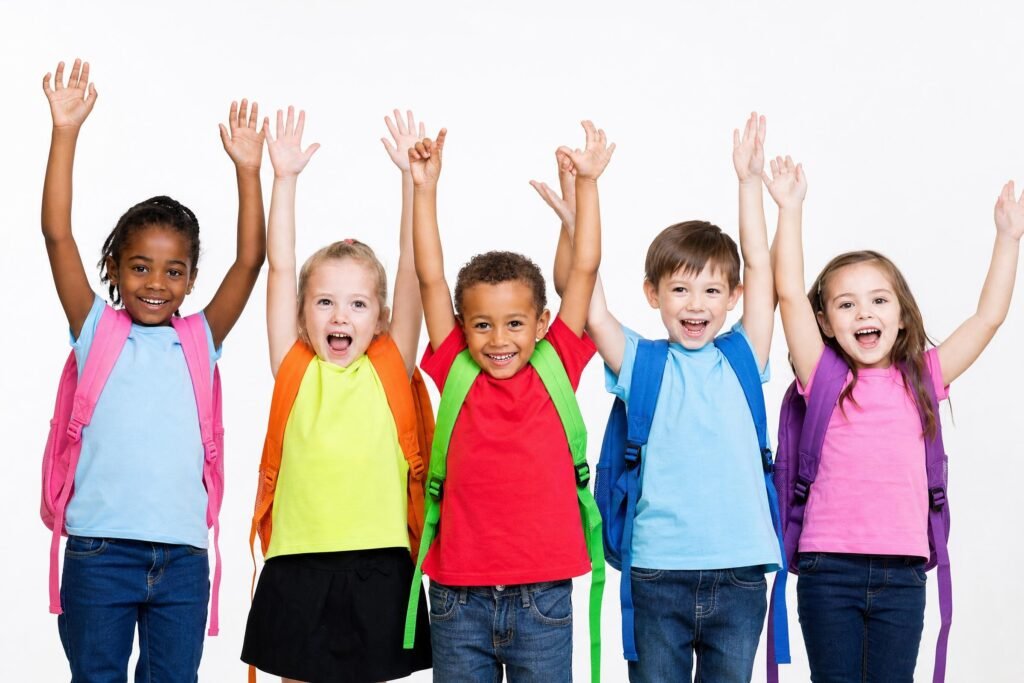 A row of smiling diverse young children with colorful backpacks raising their arms in celebration white background | edCircuit A row of smiling diverse young children with colorful backpacks raising their arms in celebration white background