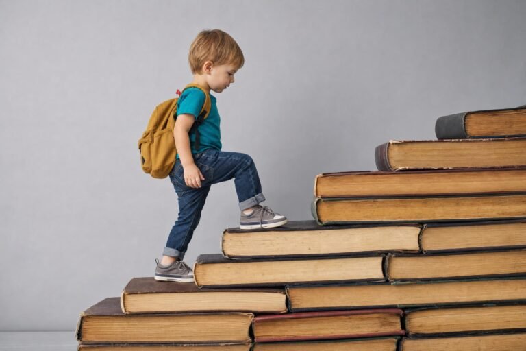 A small child with a backpack climbing a staircase made of large stacked old books, plain grey background
