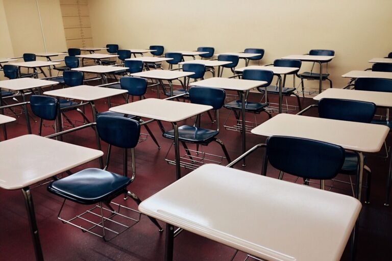 An empty classroom featuring neatly arranged desks and chairs ready for use