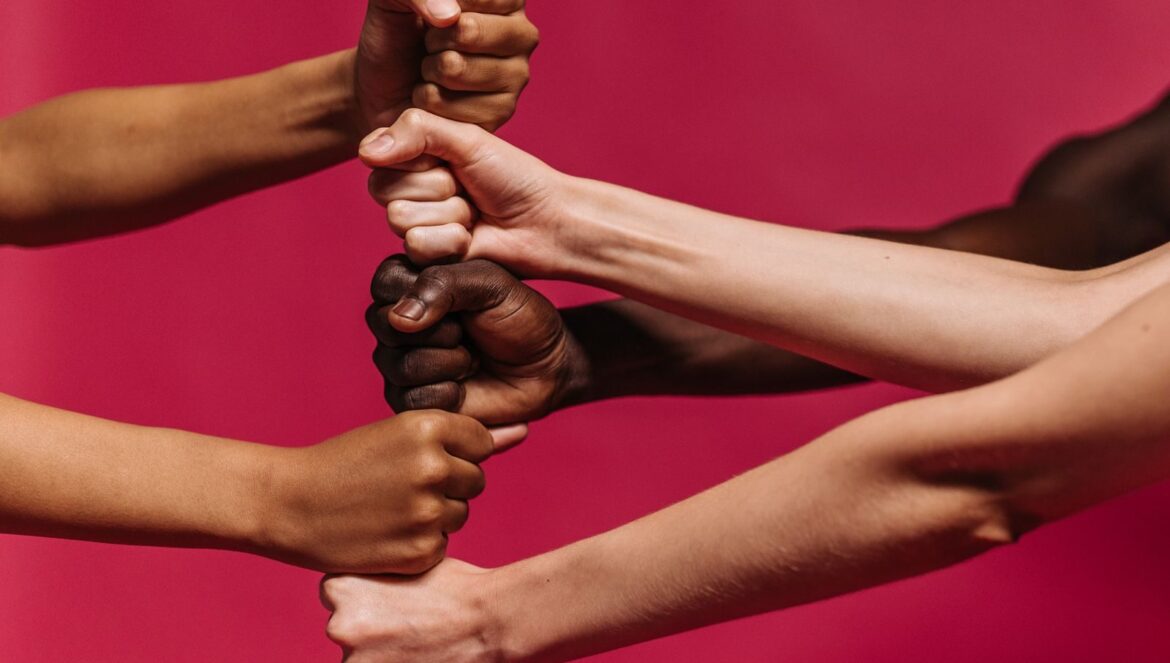 Close up of diverse hands coming together symbolizing unity and streng