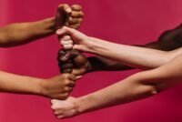 Close-up of diverse hands coming together symbolizing unity and streng