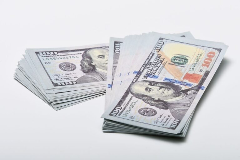 Close-up of two stacks of 0 US dollar bills on a white surface, showcasing currency and finance concepts