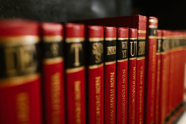 Close-up view of red leather bound encyclopedias on a bookshelf in a library