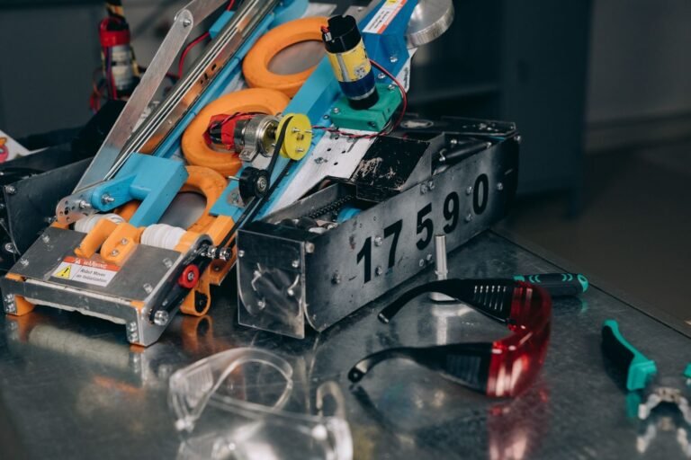Detailed shot of a robotics machine with safety glasses and tools on metal surface