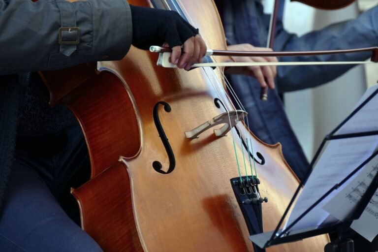 Detailed view of a cellist playing in an indoor setting with music notes visible