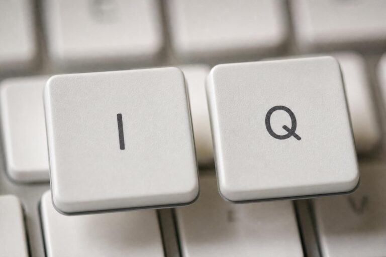 Close-up of two white keyboard keys printed with the letters I and Q, the rest of the keyboard blurred