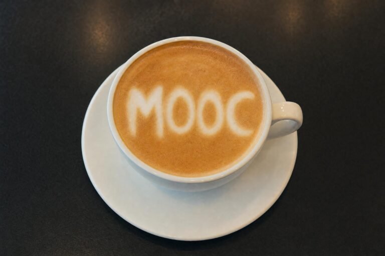 A cup of latte on a saucer seen from above with the milk foam art spelling MOOC, dark table, soft cafe light