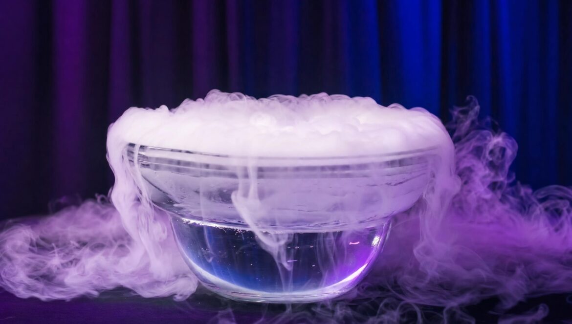 A glass bowl of water with dry ice billowing thick white fog over the rim on a dark table lit with purple and blue stage light | edCircuit A glass bowl of water with dry ice billowing thick white fog over the rim on a dark table lit with purple and blue stage light