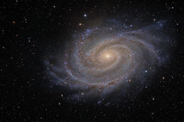 A spiral galaxy surrounded by stars in deep space, as seen through a large telescope