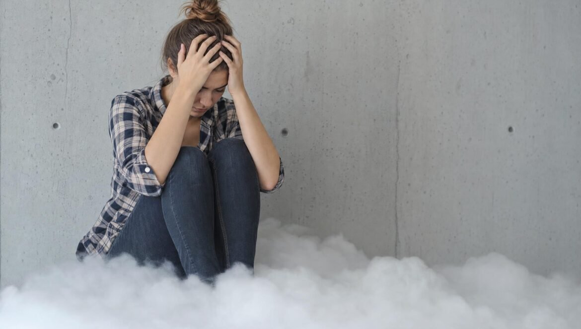 A worried young woman in a plaid shirt sitting with her head in her hands on a low white cloud of fog against a pale gray concrete wall soft diffuse light | edCircuit A worried young woman in a plaid shirt sitting with her head in her hands on a low white cloud of fog against a pale gray concrete wall soft diffuse light