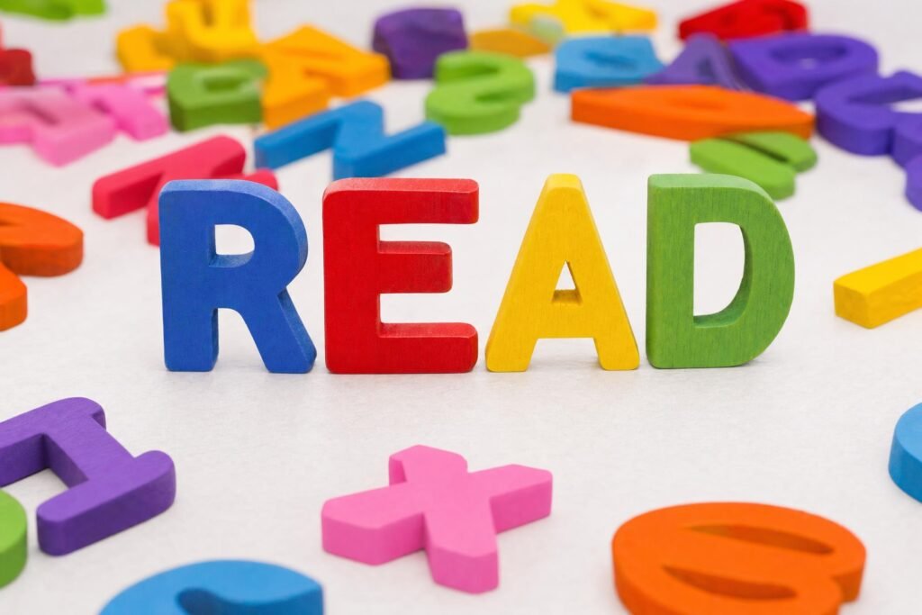 Colorful wooden alphabet letters spelling READ standing on a white table with other scattered letters around them bright soft light | edCircuit Colorful wooden alphabet letters spelling READ standing on a white table with other scattered letters around them bright soft light